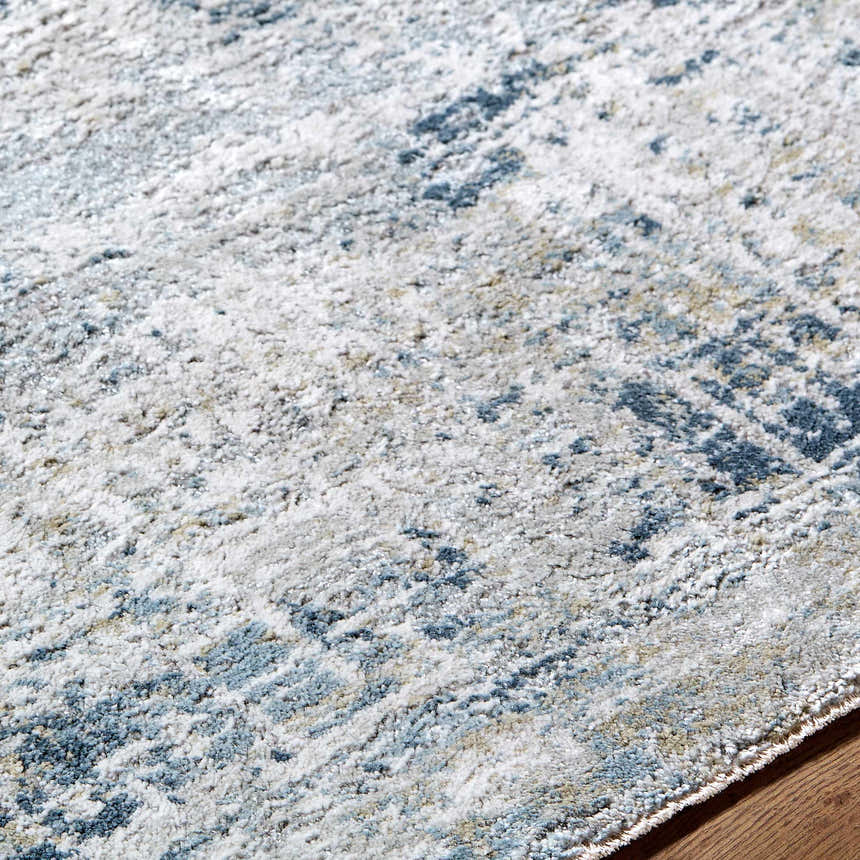 Close up of the Neron Thick Luxe Abstract Rug. Features blue, cream, and gray tones with a soft, textured pile. Texture