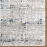 Close-up of Neron Thick Luxe Abstract Rug. Southwestern style rug in blue, charcoal, cream, and mustard. Corner