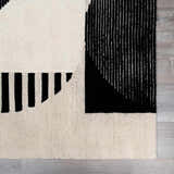 Close-up of the Brooklyn Modern hand-tufted wool area rug. Black and cream geometric pattern on a textured wool surface. Swatch