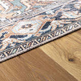 Close-up of Green Nisa Tumble Dry Washable Rug showing its Persian-style pattern, seafoam, navy, and orange colors. Corner