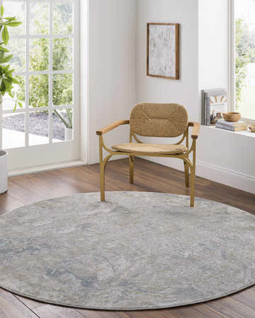 Bright room with round Nurit Blue Gray rug, wood floors, woven chair, and natural light. Roomscene-Round