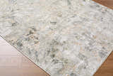 Close-up of the Nurit Sage Thick Luxe Boutique Rug. Abstract design in charcoal, cream, brown, and gray on wood floor. Corner