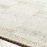 Close up of the Becki Owens x LIVABLISS BOMX-2300 area rug. Cream wool rug with tan and taupe accents. Hand tufted texture. Texture