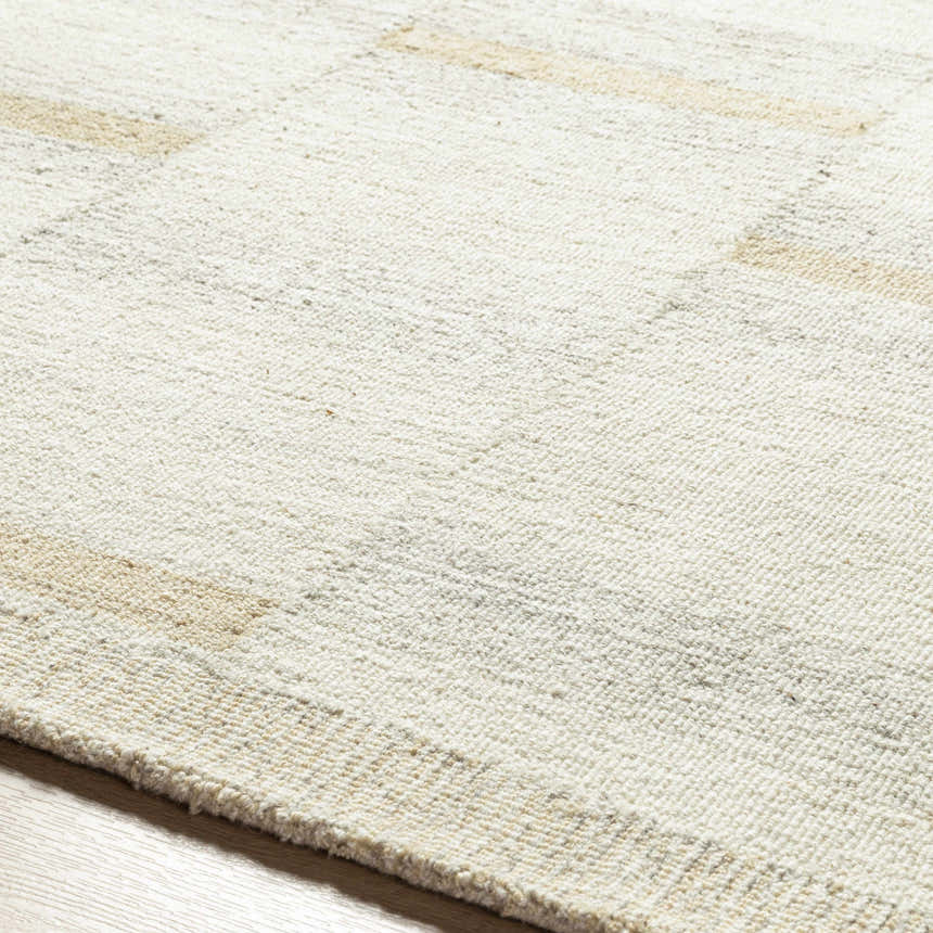 Close up of the Becki Owens x LIVABLISS BOMX-2300 area rug. Cream wool rug with tan and taupe accents. Hand tufted texture. Texture
