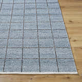 Close up of the hand woven Ayinde Area Rug. Slate blue recycled yarn with a contemporary grid pattern. Front