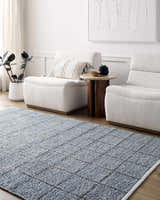 Living room scene with slate blue Ayinde Area Rug, white chairs, wood side table, and modern art. Roomscene-Rectangle