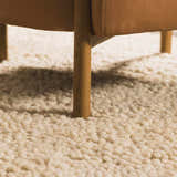 Close-up of the cream Oakridge Area Rug showing its hand woven texture and a chair leg. Roomscene-Rectangle