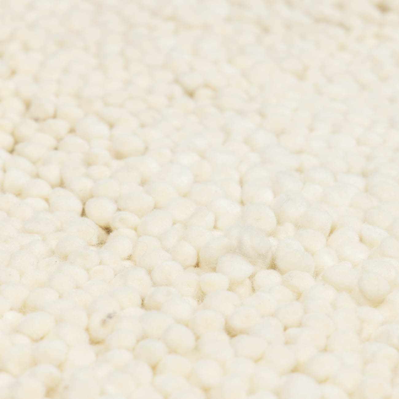 Close-up of the cream Oakridge Area Rug showing its hand-woven wool texture and looped design. Texture