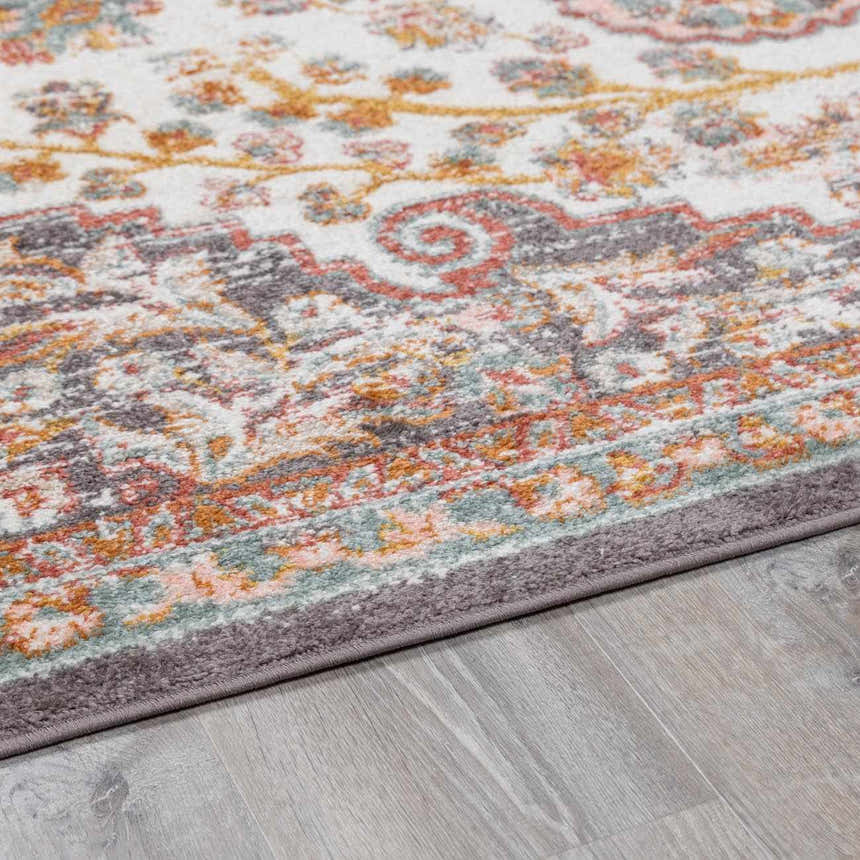 Close-up of Oark Floral Medallion Area Rug. Features brick red, camel, and dusty pink floral pattern on off-white. Pile