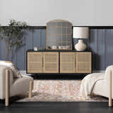 Living room scene with Oark Floral Medallion Area Rug in brick red and pink tones, styled with a rattan cabinet and cream armchairs. Roomscene-Rectangle