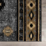 Close-up of the Buckhaven Area Rug featuring a Southwestern-inspired geometric pattern in black, gray, and tan. Swatch