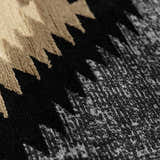 Close-up of the Buckhaven Area Rug showing a black, tan, and gray Southwestern-style geometric pattern. Texture