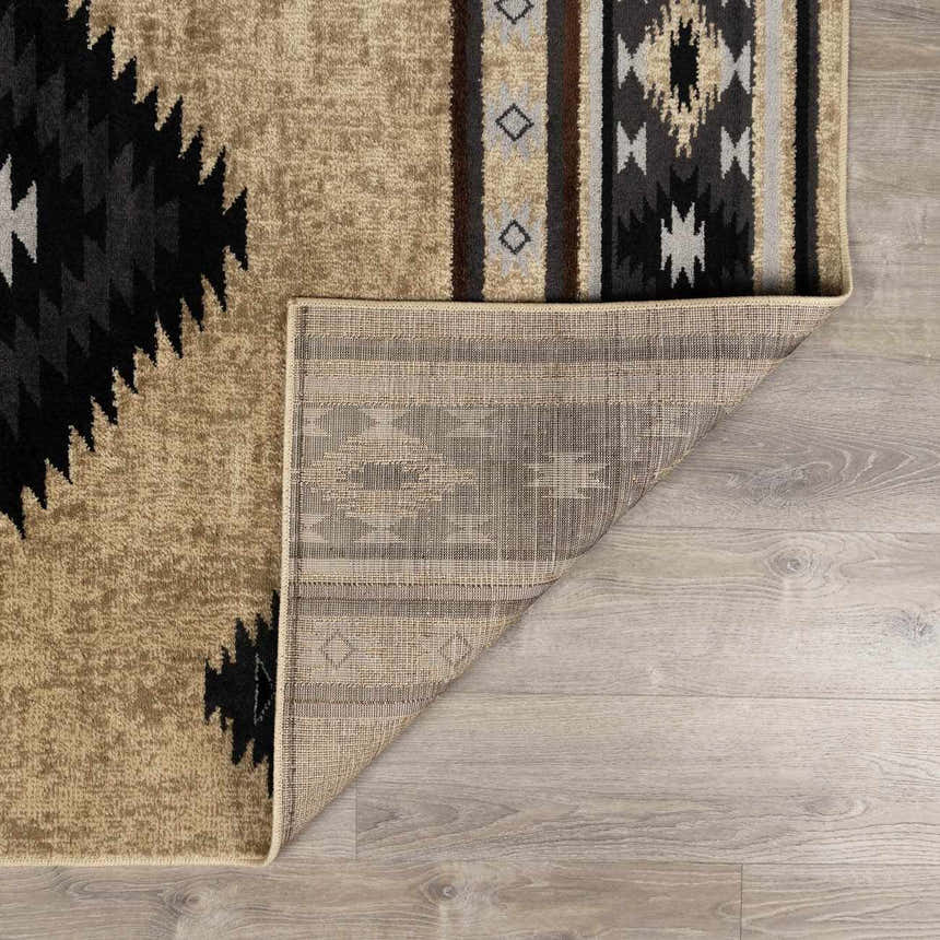Close-up of Buckhaven Brown Aztec Carpet showing the geometric pattern, colors, and backing. Fold