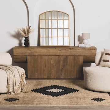 Living room scene with a Buckhaven Brown Aztec Carpet, beige chairs, and a wood console table. Roomscene-Rectangle