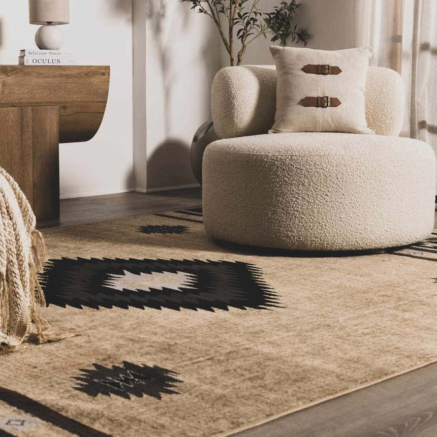Living room scene with a Buckhaven Brown Aztec Carpet, cream chair, and wood accents. Bohemian style. Roomscene-Rectangle