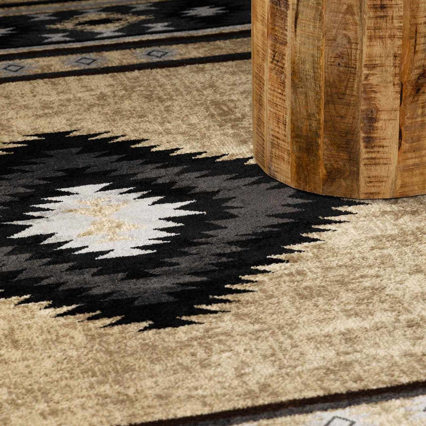 Close-up of the Buckhaven Brown Aztec Carpet with black, brown, and beige geometric patterns and a textured, machine-woven pile. Styleshot
