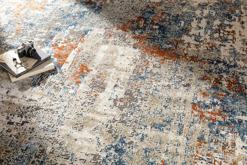 Close-up of the Priscilla Area Rug showing its contemporary burnt orange, blue, and beige abstract design. Styleshot