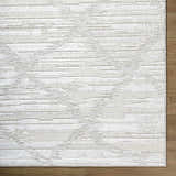 Close up of Akilah Area Rug showing cream, ivory, and light gray contemporary design and texture. Corner