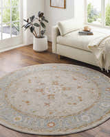Bright living room with a round Phyllis Thick Luxe Statement Rug in light beige, blue, and rust tones. Roomscene-Round
