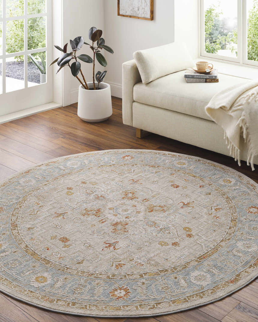 Bright living room with a round Phyllis Thick Luxe Statement Rug in light beige, blue, and rust tones. Roomscene-Round