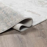 Close-up of the Pialba rug showing its abstract smokey design, luxe texture, and colors like light gray and dusty sage. Fold