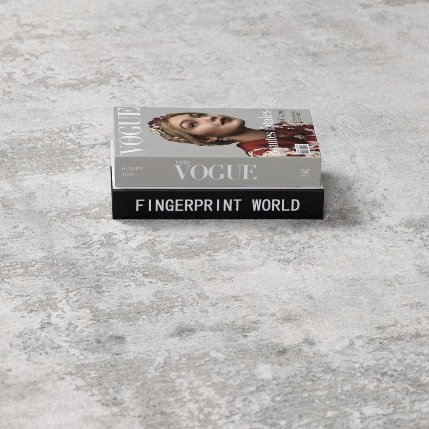 Close-up of the Pialba Thick Luxe Abstract Smokey Rug with smokey gray, white, and taupe abstract pattern and book decor. Styleshot