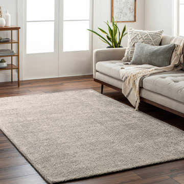 Living room scene with a neutral sofa and the Pantubig Area Rug in charcoal, gray, and ivory on dark wood floors. Roomscene-Rectangle