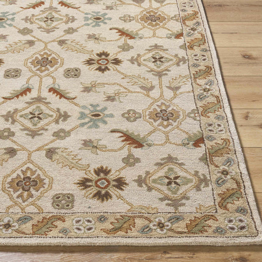 Close-up of the Postelle Wool Rug showing its traditional floral pattern and soft brown, sage, and tan colors. Hand-tufted texture. Front