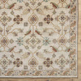 Close-up of the Postelle Wool Rug. Hand-tufted rug with a traditional floral pattern in brown, sage, and tan on a cream background. Corner
