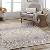 Living room scene with a gray chair and Poydras High-Low Rustic Rug in charcoal, gray, and beige tones. Roomscene-Rectangle
