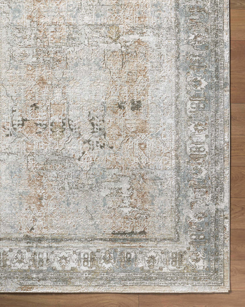 Close-up of the Pryce Sage rug showing a traditional design in cream, light brown, and light gray on a wood floor. Corner