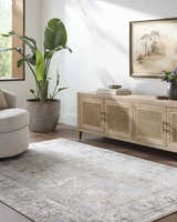 Living room scene with Pryce Sage Thick Luxe Area Rug, beige swivel chair, and light wood media console. Roomscene-Rectangle