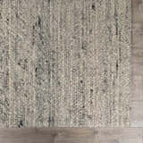Close-up of the Olisa Gray Wool Area Rug showing its hand woven texture and light gray and natural gray color variations. Swatch