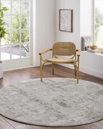 Bright living room with round Pixie Thick Luxe Boutique Rug in charcoal, cream, and light brown under a woven chair. Roomscene-Round