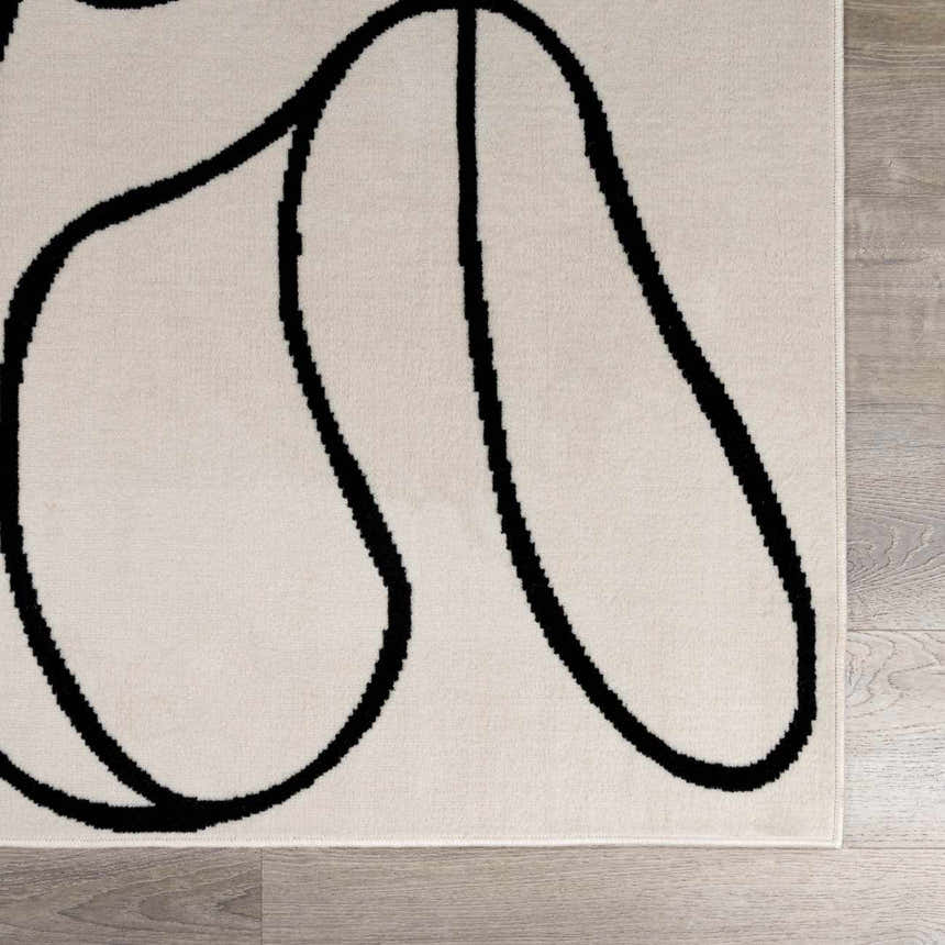 Close-up of the Eilir rug, showing its bone color and bold, black abstract line design. Modern boho style. Swatch