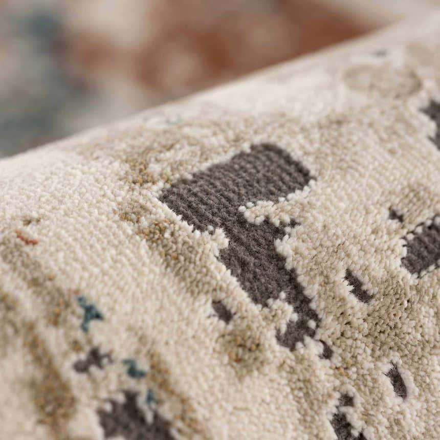 Close-up of the Priscilla Area Rug showing its light beige, tan, and dark brown contemporary design and soft texture. Fold