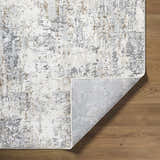 Close-up of the Avital Neutral Abstract Area Rug showing charcoal, gray, light brown, and white tones on wood flooring. Fold