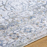 Close-up of the Annlea Washable Area Rug, featuring a farmhouse design in blue, sage, slate blue, and white polyester. Texture
