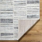 Close-up of Allete Broken-Striped Area Rug showing ash, light silver, and gray tones with a textured, machine-woven design. Fold