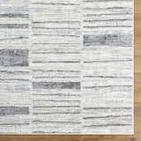 Close-up of Allete Broken-Striped Area Rug showing its ash, light silver, and silver gray contemporary design. Corner