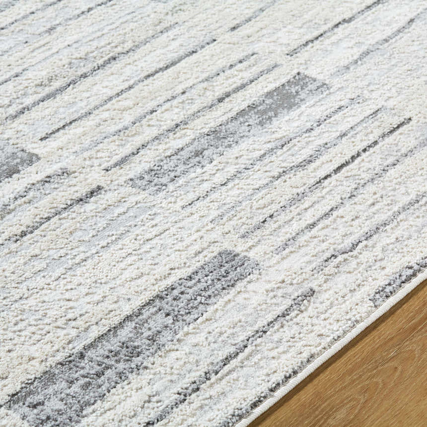 Close-up of the Allete Broken-Striped Area Rug. Ash, light silver, and silver gray broken stripe design. Contemporary style. Texture