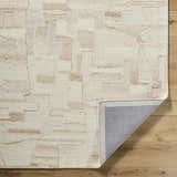 Close-up of the Aintza Area Rug. Hand-tufted wool rug in beige, cream, ivory, and tan with a geometric pattern. Fold
