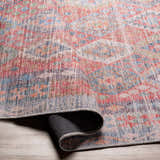 Close-up of the Ranao Washable Area Rug showing its traditional, vintage design with blue, red, peach, and green colors. Fold