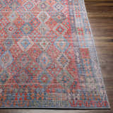 Close up of Ranao Washable Area Rug. Traditional design in blue, red, peach, and green on dark wood floor. Front
