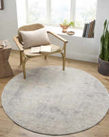 Cozy reading nook with round Razi Avant Garde rug in brown, gray, and sage. Wicker chair, wood floors, and natural light. Roomscene-Round