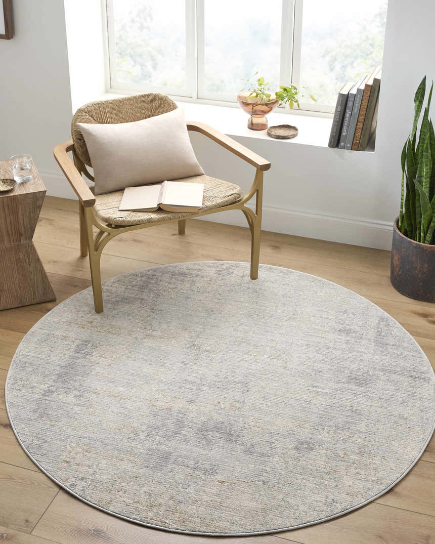 Cozy reading nook with round Razi Avant Garde rug in brown, gray, and sage. Wicker chair, wood floors, and natural light. Roomscene-Round
