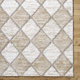 Close up of Aideen Cream Shag Area Rug featuring a diamond pattern in cream, light brown, and gray on wood floors. Corner