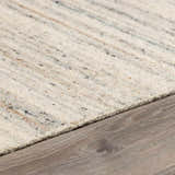 Close-up of the hand-tufted Capote Ivory Area Rug showing wool texture and charcoal, tan, and taupe color variations. Pile