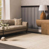 Living room scene with a neutral sofa and the Capote Ivory Area Rug. The rug is a light, warm color. Roomscene-Rectangle