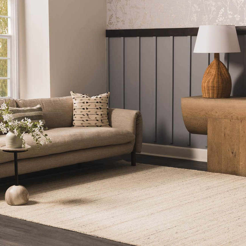 Living room scene with a neutral sofa and the Capote Ivory Area Rug. The rug is a light, warm color. Roomscene-Rectangle